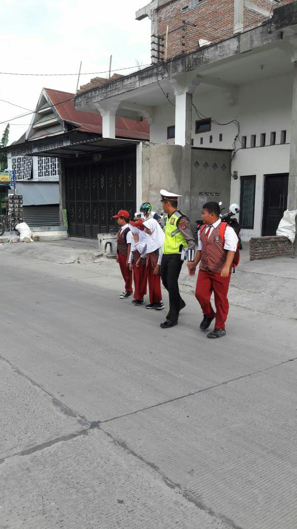 Pak Polisi Lantas Ini Bantu Nyebrangin Anak-anak 