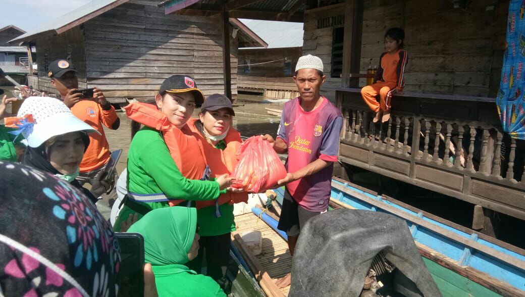 Gunakan Perahu, Persit KCK Cab XLIV Dim 1420 Bagikan Bantuan pada Korban Banjir di Wette’e