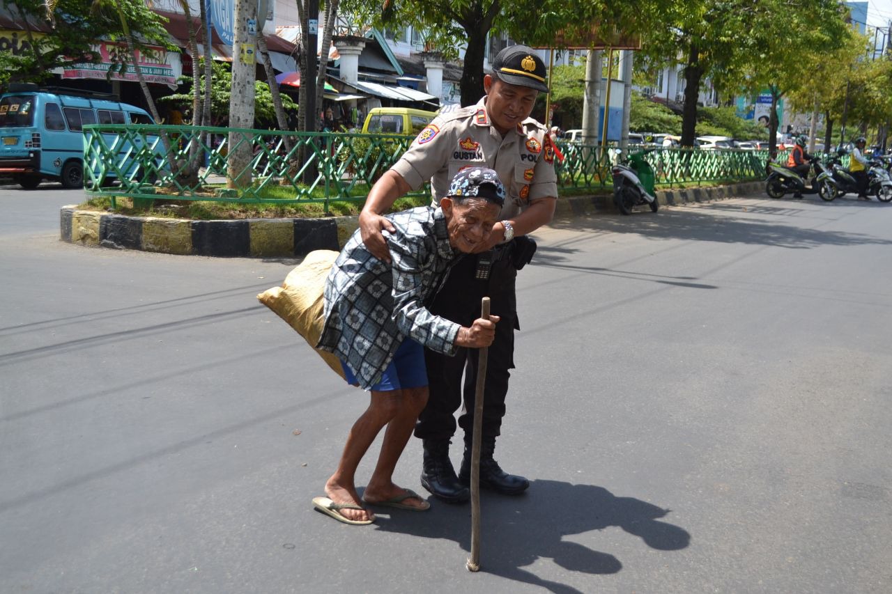 Berjiwa Pelayan, Kasiwas Polres Palopo Bantu Kakek Lansia Menyeberang Jalan