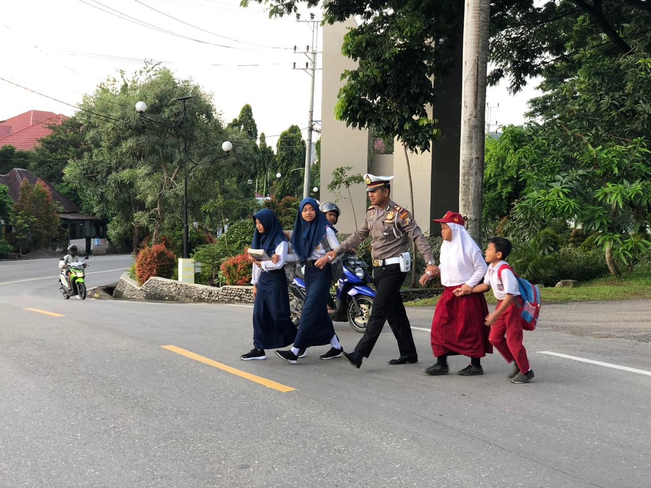 Bentuk Pelayanan Prima, Kasat Lantas Polres Enrekang Bantu Anak Sekolah Menyeberang Jalan