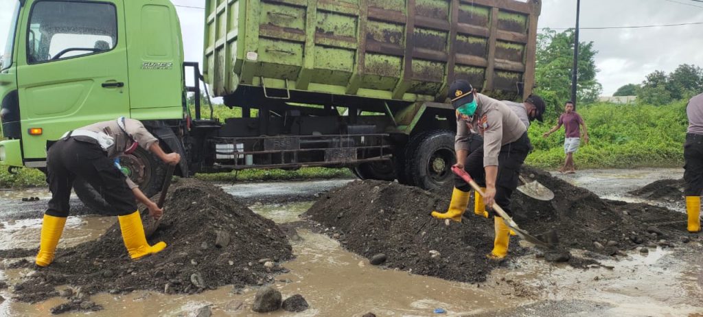 Peduli Lakalantas, Polsek Batui Ajak Warga Timbung Lubang di Jalan Raya