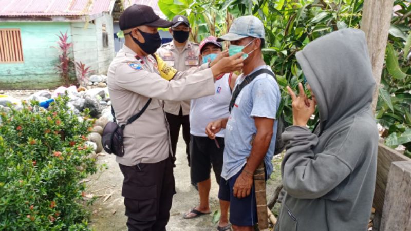 Bagikan Masker, Polisi di Batui Ingatkan Warga Tetap Patuhi Protokol Kesehatan