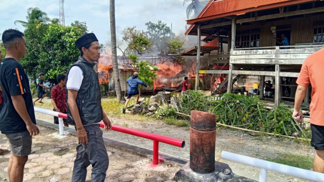 Kebakaran rumah panggung di Kecamatan Gilireng, Wajo, petugas dan warga berusaha memadamkan api.