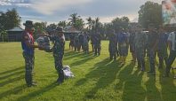 Kapten Zabir menyerahkan seragam TMMD kepada anggota Satgas saat apel pagi di Desa Temmabarang, Wajo.