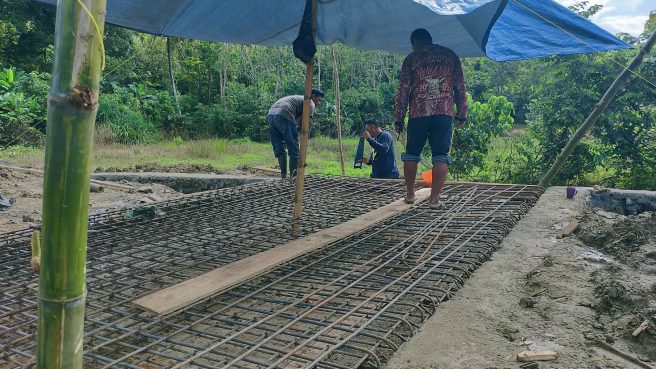 Prajurit TNI dan warga bergotong royong memasang rangka besi jembatan dalam program TMMD ke-124 di Desa Temmabarang, Wajo.
