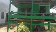 Anggota TNI bersama warga berdiri di depan rumah hasil program TMMD di Desa Temmabarang, Wajo