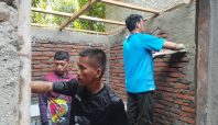 Anggota Satgas TMMD bersama warga Desa Temmabarang sedang mengerjakan pembangunan fasilitas MCK dengan cara memplester dinding bata merah di Kabupaten Wajo.