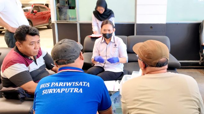 Petugas Tim K3 Kemnaker sedang melakukan pemeriksaan kesehatan dan tensi kepada sopir bus pariwisata Suryaputra untuk persiapan mudik Lebaran.
