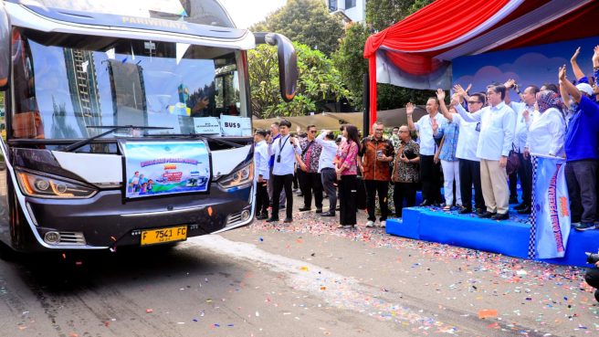 Menteri Ketenagakerjaan Yassierli bersama jajaran BPJS Ketenagakerjaan melambaikan tangan saat melepas bus mudik gratis pekerja di halaman kantor Kemnaker.