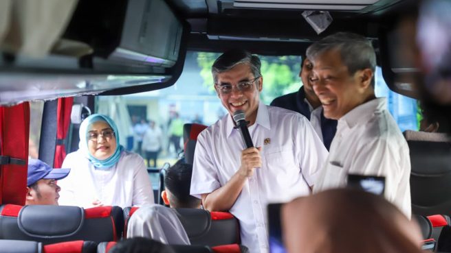Menteri Ketenagakerjaan Yassierli menyapa para pemudik di dalam bus mudik gratis PT Pamapersada Nusantara.