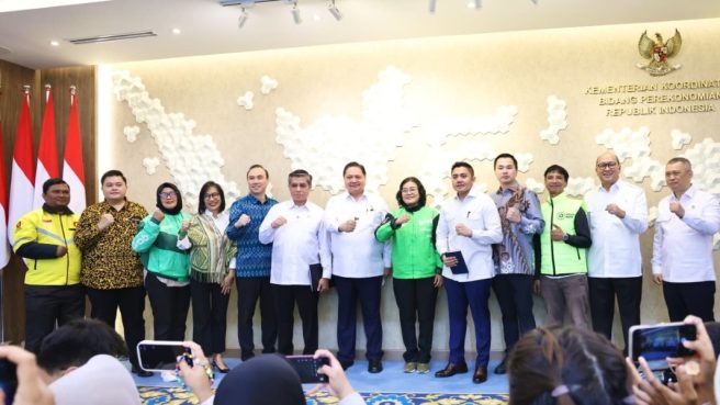 Foto bersama setelah konferensi pers mengenai kebijakan THR dan BHR 2026, menampilkan Menteri Ketenagakerjaan Yassierli di tengah bersama jajaran pejabat kementerian, perwakilan perusahaan aplikasi, serta pengemudi ojek online dan kurir yang mengenakan jaket seragam hijau dan kuning, semuanya berpose kompak mengepalkan tangan.