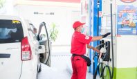 Operator SPBU Pertamina dengan seragam merah dan masker melakukan pengawasan ketat saat mengisi BBM subsidi ke mobil konsumen di Situbondo.