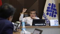 Menteri Ketenagakerjaan (Menaker) Yassierli duduk di ruang rapat Kemnaker mengenakan kemeja putih, memberikan penjelasan dengan gestur tangan, di depannya ada laptop dan papan nama 'MENAKER RI'.