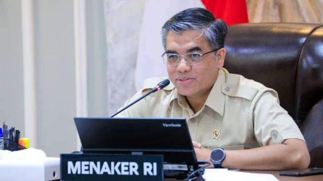 Menaker Yassierli berbicara di depan mikrofon mengenai pendaftaran K3 gratis.