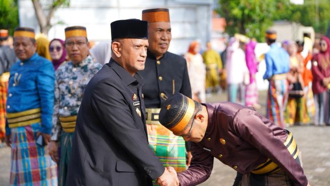 dr. Baso Rahmanuddin mengenakan Pakaian Sipil Resmi (PSR) bersalaman dengan tokoh adat di Wajo.